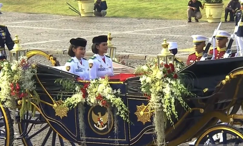 Dua Purna Paskibraka Duta Pancasila 2025 mengantar bendera pusaka dan teks proklamasi dari Monumen Nasional menuju Istana Merdeka dalam prosesi kirab Merah Putih di Jakarta Senin (17/8/2026) Foto: ANTARA