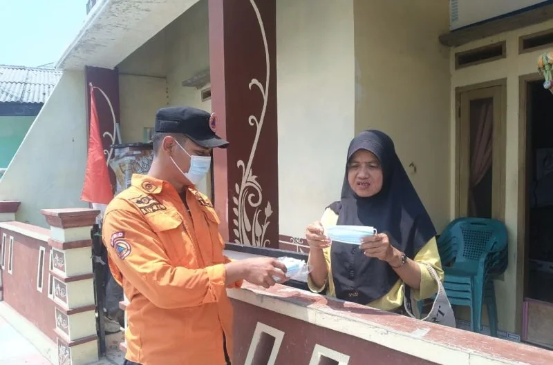 Petugas membagikan masker kepada masyarakat di Kabupaten Kepulauan Seribu, yang terpapar sebaran abu vulkanik Gunung Anak Krakatau. Foto: Pemkab Kepulauan Seribu