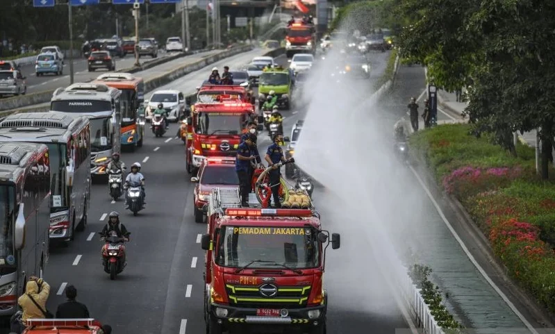 Petugas Gulkarmat DKI Jakarta menyemprotkan air di Jalan Jenderal Sudirman, Jakarta, Minggu (6/9/2026) sebagai langkah antisipasi dampak dari paparan abu vulkanik Gunung Anak Krakatau. Foto: ANTARA