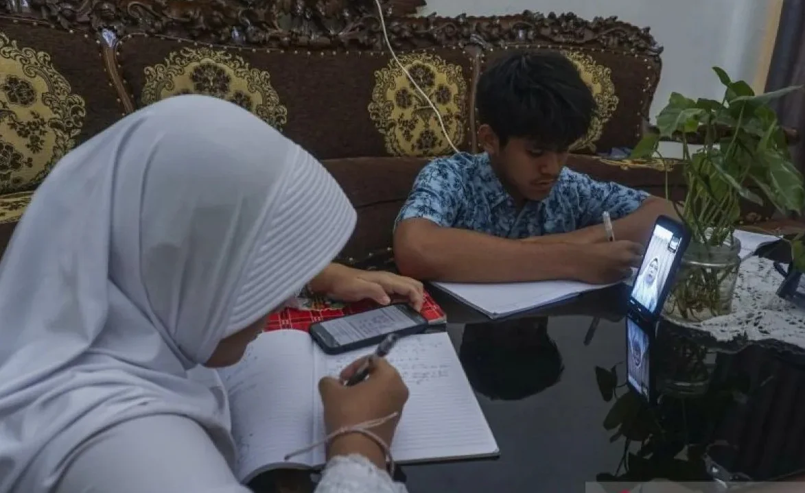 Siswa mengikuti pelajaran secara daring dari rumahnya di Meruya, Jakarta, Jumat (23/1/2026). Pemerintah Provinsi DKI Jakarta memberlakukan kebijakan Pembelajaran Jarak Jauh (PJJ) untuk satuan pendidikan menyikapi perkembangan cuaca hingga 28 Januari 2026.