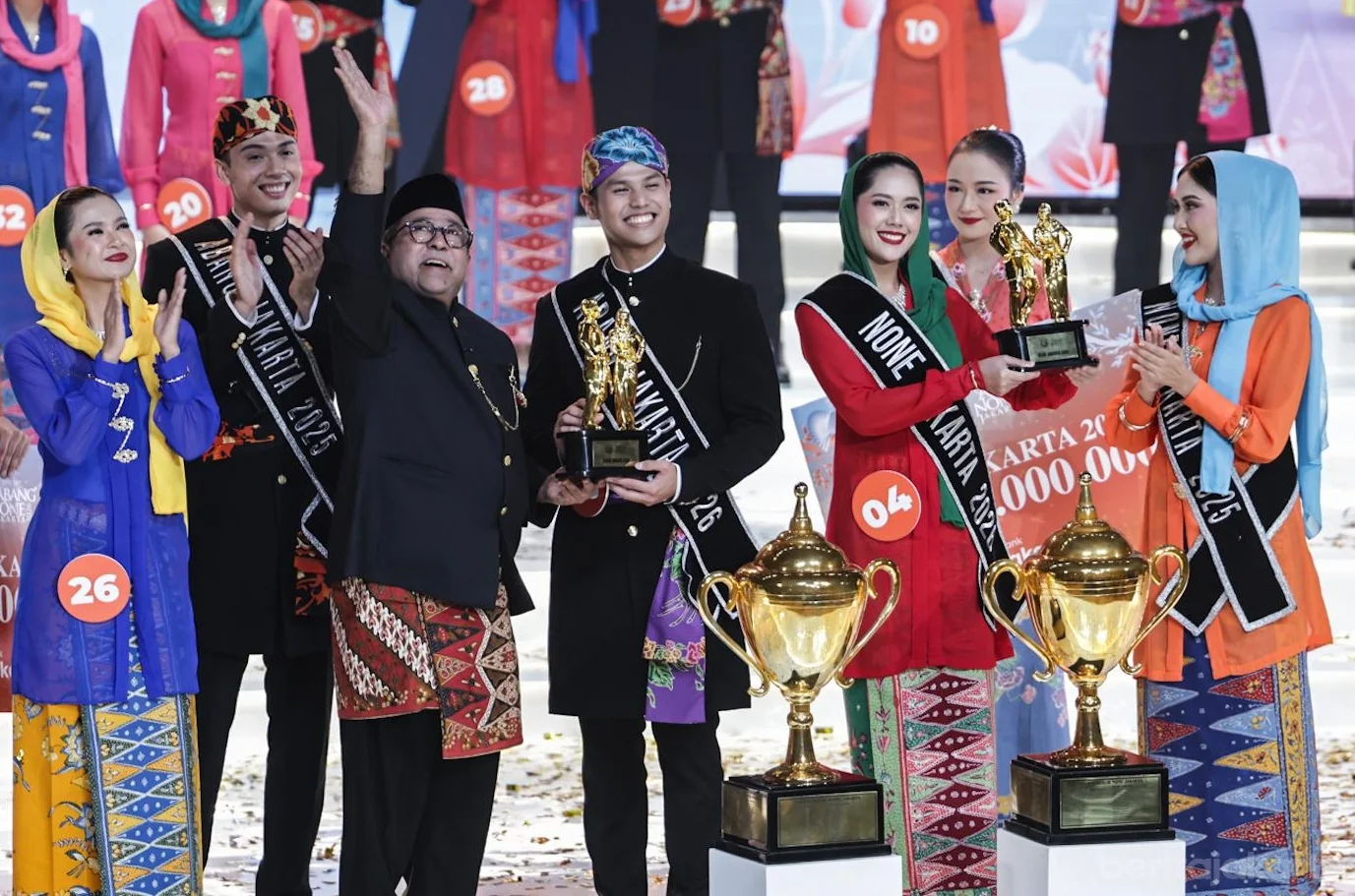 Wakil Gubernur DKI Jakarta Rano Karno memberikan piala kepada Abang None Jakarta 2026 terpilih yakni Herve Pierre Sidarta dari Jakarta Selatan dan Citra dari Jakarta Timur. Foto: Pemprov DKI