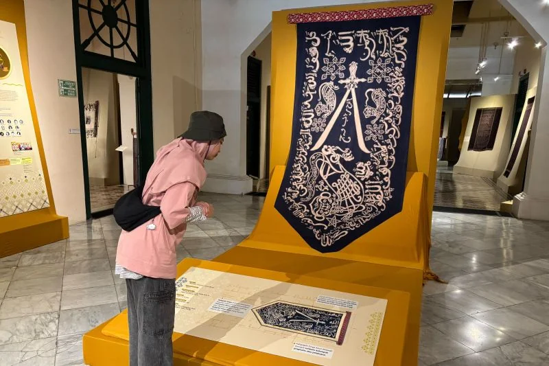 Pengunjung mengamati umbul-umbul Caruban Nagari Keraton Cirebon dalam pameran "Menjaga Warisan untuk Masa Depan" di Museum Tekstil, Jakarta, Kamis (13/8/2026). Pameran masih berlangsung hingga 30 Agustus 2026. Foto: ANTARA