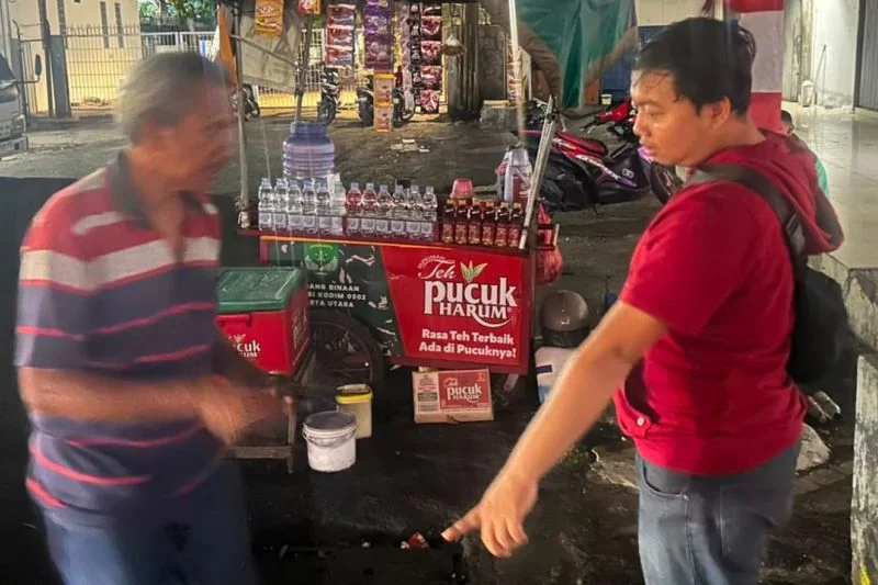 Korban penipuan dan penggelaran berinisial HRN (kiri) bersama gerobak kopi yang kehilangan satu unit sepeda motor di kawasan Kelapa Gading, Jakarta Utara pada Minggu (23/8/2026) Foto: Polsek Kelapa Gading